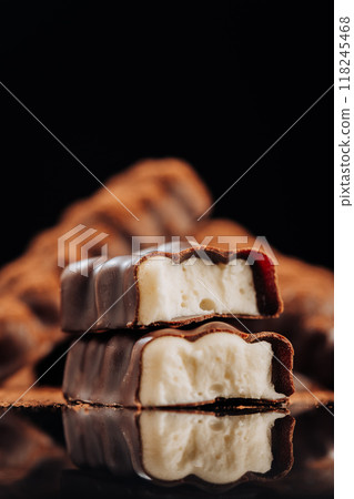 Chocolate bar with creamy filling on dark background, ideal for dessert and confectionery concepts Chocolate bar with creamy filling on dark background, ideal for dessert and confectionery concepts 118245468