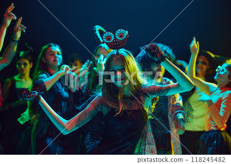 Friends in various Halloween costumes gathering at nightclub for cheerful and energetic celebration. dancing, and laughing. Friends in various Halloween costumes gathering at nightclub for cheerful and energetic celebration. dancing, and laughing. 118245482
