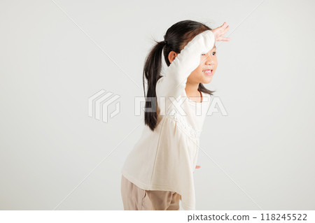 Searching concept. Asian young girl kid looking far away with hand over head at studio shot isolated on white background, Portrait of Happy kindergarten child looking at distance with eyes shaded Searching concept. Asian young girl kid looking far away with hand over head at studio shot isolated on white background, Portrait of Happy kindergarten child looking at distance with eyes shaded 118245522