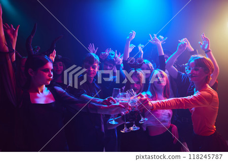 Lemonade, dances and laugh. Group of people, friends gathering at nightclub to celebrate Halloween. Wearing costumes and makeup of supernatural characters 118245787