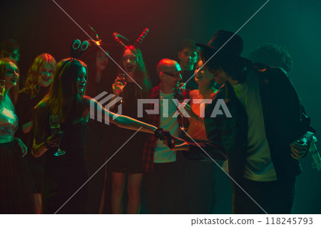 Invitation for a dance. Halloween party scene with young people dressed as ghosts, witches, and vampires. Cheerful celebration, laugh and joy Invitation for a dance. Halloween party scene with young people dressed as ghosts, witches, and vampires. Cheerful celebration, laugh and joy 118245793