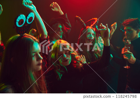 Young cheerful people, friends gathering at nightclub to celebrating Halloween, attending lively party, with costumes ranging from spooky to silly 118245798