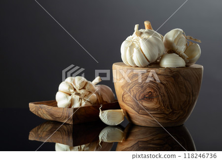 Garlic bulbs on a black reflective background. 118246736