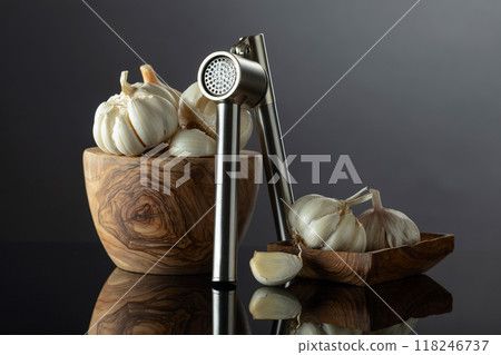 Garlic bulbs and garlic press on a black background. Garlic bulbs and garlic press on a black background. 118246737