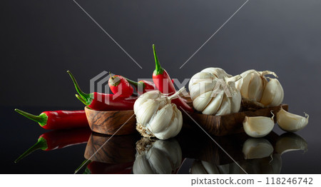 Garlic bulbs and red chili peppers on a black background. Garlic bulbs and red chili peppers on a black background. 118246742