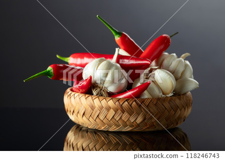 Garlic bulbs and red chili peppers on a black background. Garlic bulbs and red chili peppers on a black background. 118246743