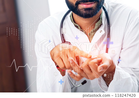 A man in a white lab coat is pointing at a heart on a computer screen A man in a white lab coat is pointing at a heart on a computer screen 118247420