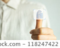 A person is holding a finger up to a screen that has a fingerprint on it 118247422