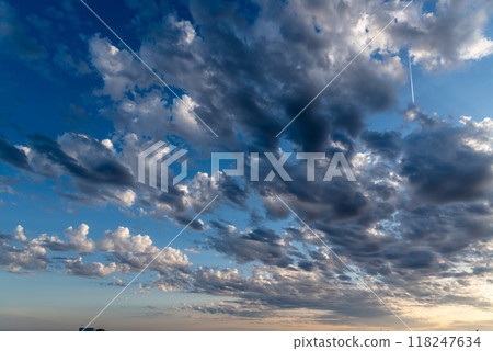 Beautiful white puffy clouds against blue sky during dramatic sunset Beautiful white puffy clouds against blue sky during dramatic sunset 118247634