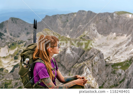 Woman Tourist with Backpack Sitting on Mountain Top Woman Tourist with Backpack Sitting on Mountain Top 118248401