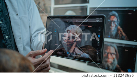Archaeologists study anatomy of fossil skull using tablet with 3D visualization of ancient human Archaeologists study anatomy of fossil skull using tablet with 3D visualization of ancient human 118248686