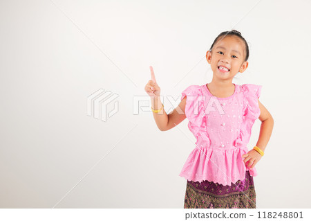 Portrait Thailand kid girl smiling traditional Thai dress costume indicate finger empty space, studio isolated white background, kindergarten child pointing index out with copy space Portrait Thailand kid girl smiling traditional Thai dress costume indicate finger empty space, studio isolated white background, kindergarten child pointing index out with copy space 118248801
