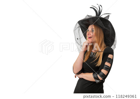 Attractive young woman in a black witch hat looks with surprise. Halloween costume, white background, space for text 118249361