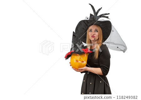 Dissatisfied woman in black witch hat with jack o lantern in hands. White background. Halloween costume party. Copy space Dissatisfied woman in black witch hat with jack o lantern in hands. White background. Halloween costume party. Copy space 118249382