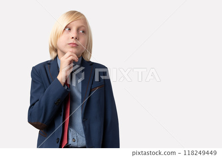 Portrait of pensive young blond man with short hair, keeps hand on chin, ponders something, wears blue jacket and red tie, isolated over white background. People and emotions concept Portrait of pensive young blond man with short hair, keeps hand on chin, ponders something, wears blue jacket and red tie, isolated over white background. People and emotions concept 118249449