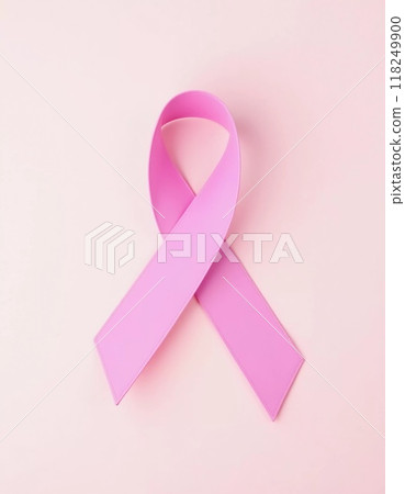 A delicate pink ribbon lies against a soft pink background, serving as a powerful symbol of cancer awareness and the ongoing fight against the disease, encouraging unity and support. Generative AI 118249900