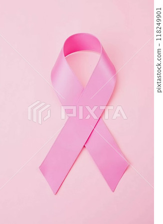 A delicate pink ribbon lies against a soft pink background, serving as a powerful symbol of cancer awareness and the ongoing fight against the disease, encouraging unity and support. Generative AI 118249901