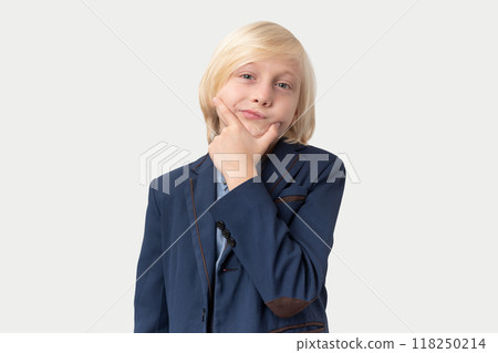 Portrait of a cute little boy with blond hair in a suit holding his chin Portrait of a cute little boy with blond hair in a suit holding his chin 118250214