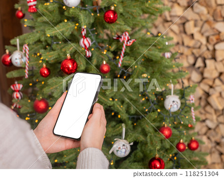 Hand using mobile phone screen mockup, smartphone display mock up on winter holiday, Christmas time Hand using mobile phone screen mockup, smartphone display mock up on winter holiday, Christmas time 118251304