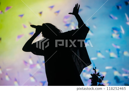 Beautiful female singer silhouette sings on stage in light show Beautiful female singer silhouette sings on stage in light show 118252465