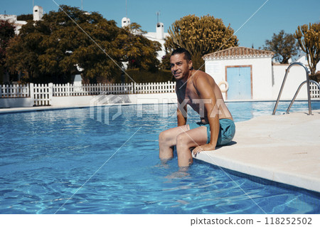 Young man relaxing in swimming pool Young man relaxing in swimming pool 118252502