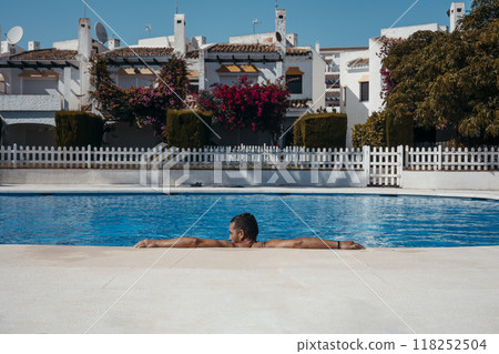Young man relaxing in swimming pool Young man relaxing in swimming pool 118252504