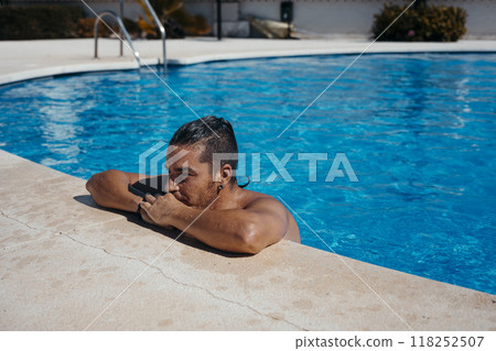 Young man relaxing in swimming pool Young man relaxing in swimming pool 118252507