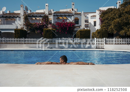 Young man relaxing in swimming pool Young man relaxing in swimming pool 118252508
