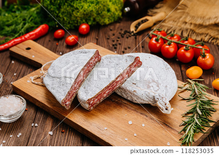 Dry-cured salami on board, ideal for rustic charcuterie presentations and gourmet food styling 118253035