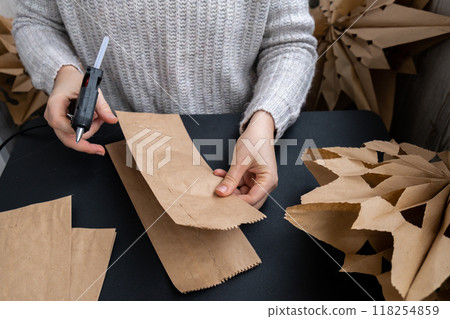 Sustainableminded Christmas cozy home handmade decoration. Tutorial for making do it yourself craft paper lunch bags and hot glue. Seasonal activity for kids. 3D snowflakes eve preparation 118254859