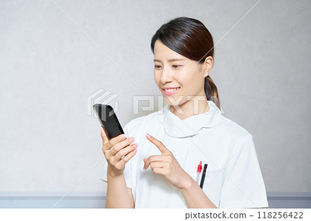 一名穿著制服的女士正在操作智慧型手機 一名穿著制服的女士正在操作智慧型手機 118256422