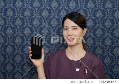 一名穿著制服的女士正在操作智慧型手機 一名穿著制服的女士正在操作智慧型手機 118256427
