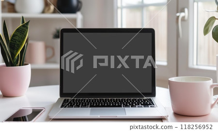 A laptop is open on a table with a cup of coffee next to it 118256952