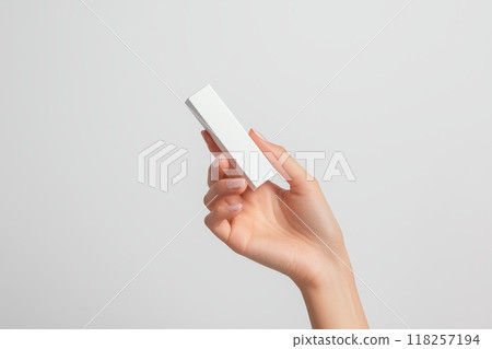 A hand holding a white lipstick box with, Mockup cosmetics product for branding A hand holding a white lipstick box with, Mockup cosmetics product for branding 118257194