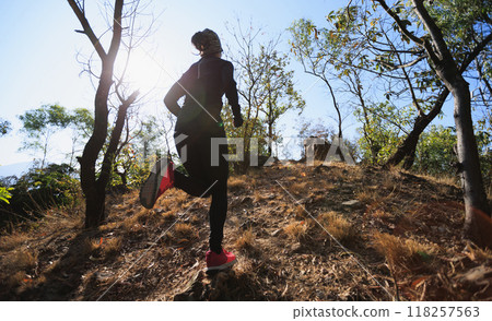 Fitness asian woman running on trail at sunrise tropical forest in winter Fitness asian woman running on trail at sunrise tropical forest in winter 118257563