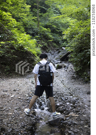 A boy climbing a mountain 118258068