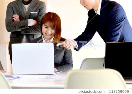 Male and female business people working on a computer Male and female business people working on a computer 118259009