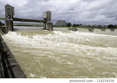 Tama River swollen from heavy rains. Opened floodgates and Nigaryokamigawara Dam. Tama River swollen from heavy rains. Opened floodgates and Nigaryokamigawara Dam. 118259156
