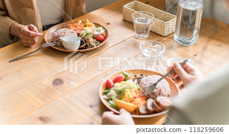 A woman eating a delicious lunch with her female friends (one plate) A woman eating a delicious lunch with her female friends (one plate) 118259606