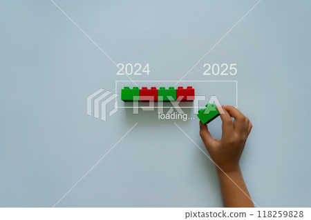 Loading new year 2024 to 2025 with child hand putting plastic block in progress bar. Loading new year 2024 to 2025 with child hand putting plastic block in progress bar. 118259828