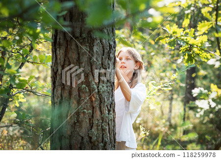 A teenage girl hugs a tree in the forest. A teenage girl hugs a tree in the forest. 118259978