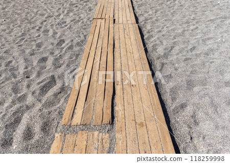 Empty wooden walkways lie on the beach sand on a sunny summer day 118259998