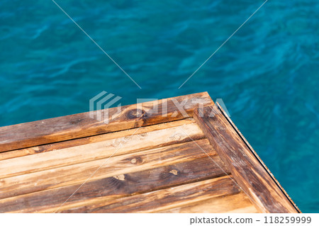 Corner of an empty wooden pier is on the blurred blue sea wate 118259999