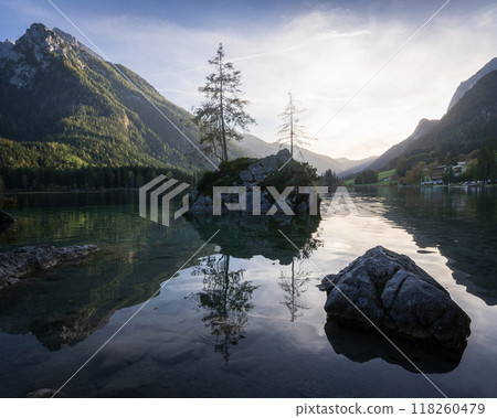 Beautiful landscape scenery with isolated rocks and tree on a surface of alpine lake during sunset 118260479