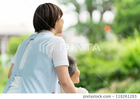 Wheelchair caregiver and senior woman, back view 118261203