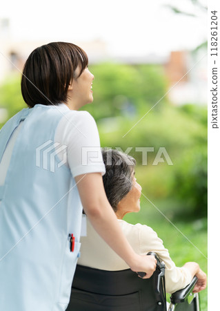 Wheelchair caregiver and senior woman, back view 118261204