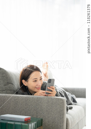 躺著，看著智能手機的女人 118261376