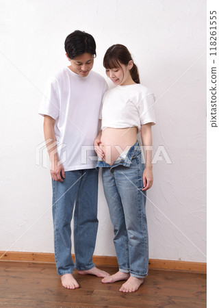A young pregnant woman with a big belly and her husband 118261555