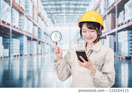 A woman in work clothes searching for inventory in a warehouse A woman in work clothes searching for inventory in a warehouse 118264115