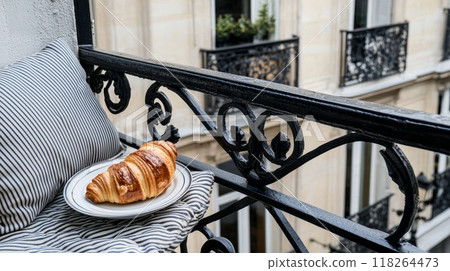 Fresh Croissant on a Balcony Railing Overlooking Classic European Architecture 118264473